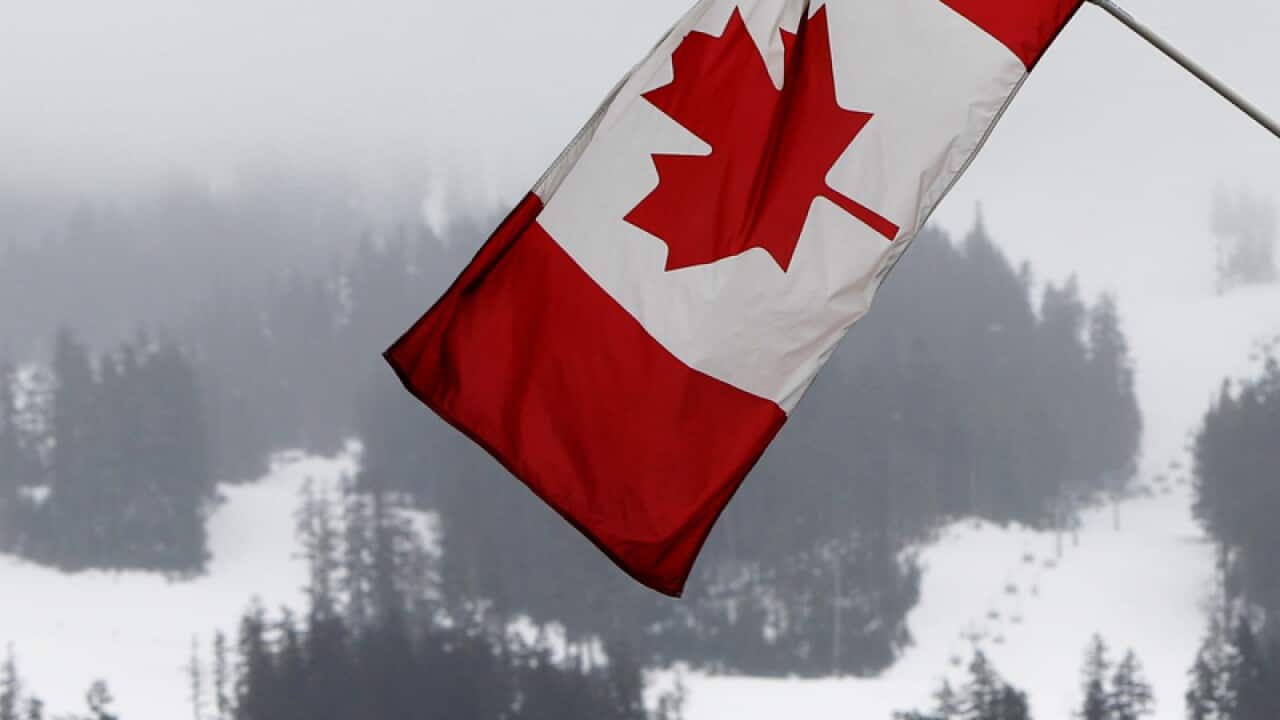 A Canadian flag against a backdrop of a ski runs, Vancouver