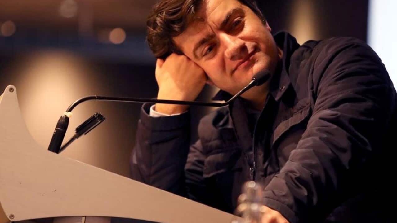 Sam Dastyari leans on a podium at an event in May.