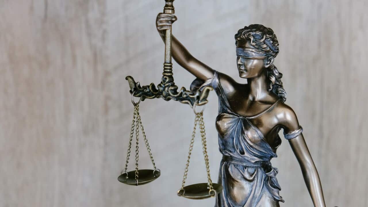 A blindfolded woman holds scales of justice.