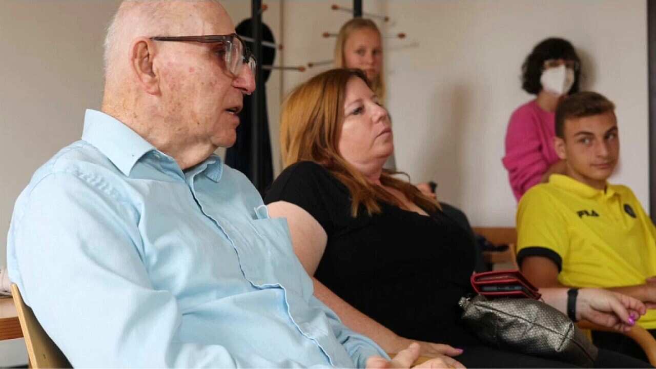 : Holocaust survivor Shaul Paul Ladany (L) speaks to young footballers in Nuremberg