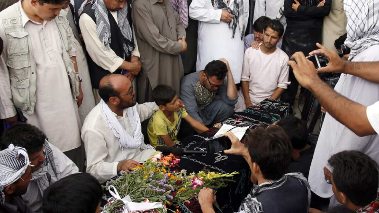 People attend the funeral of the victims of the suicide bomb attack