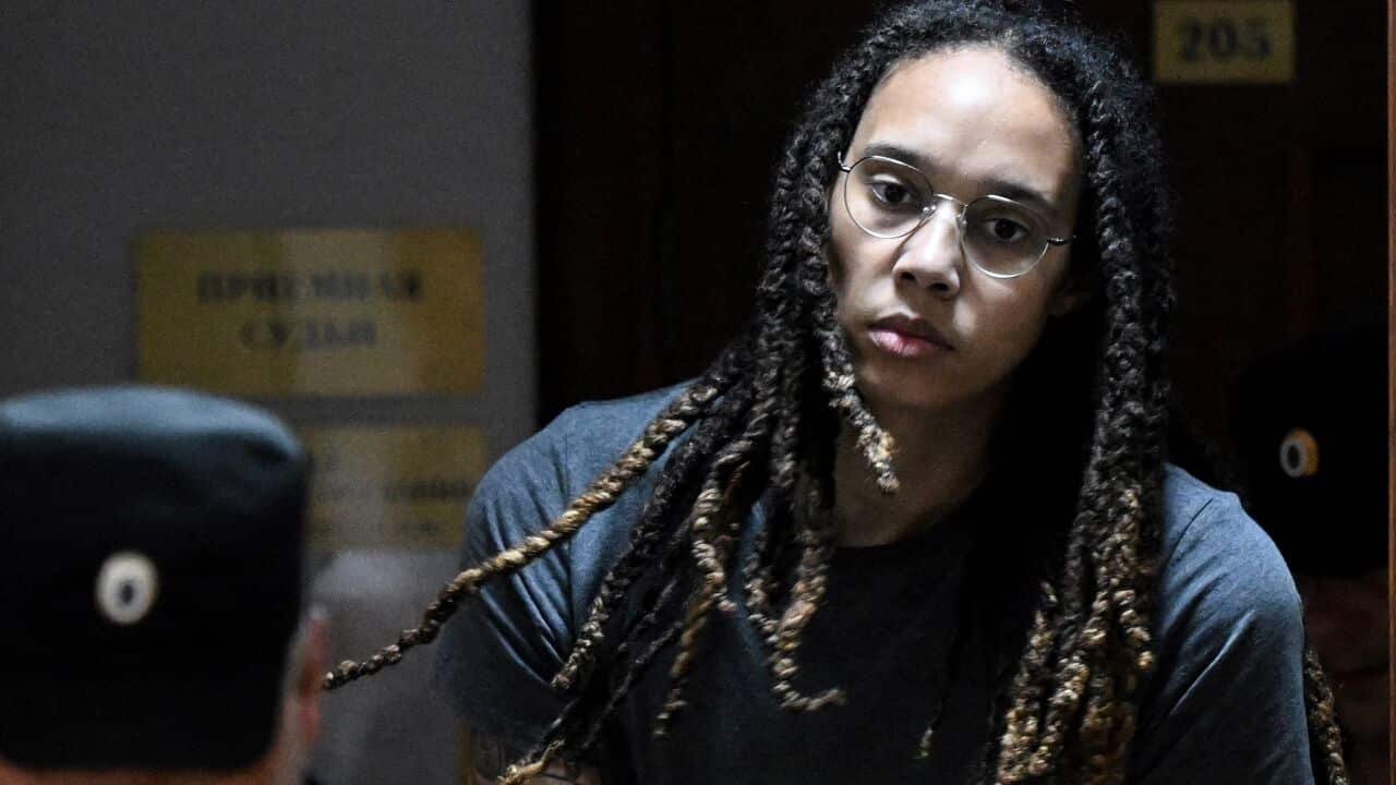 Brittney Griner in handcuffs being escorted to a courtroom.