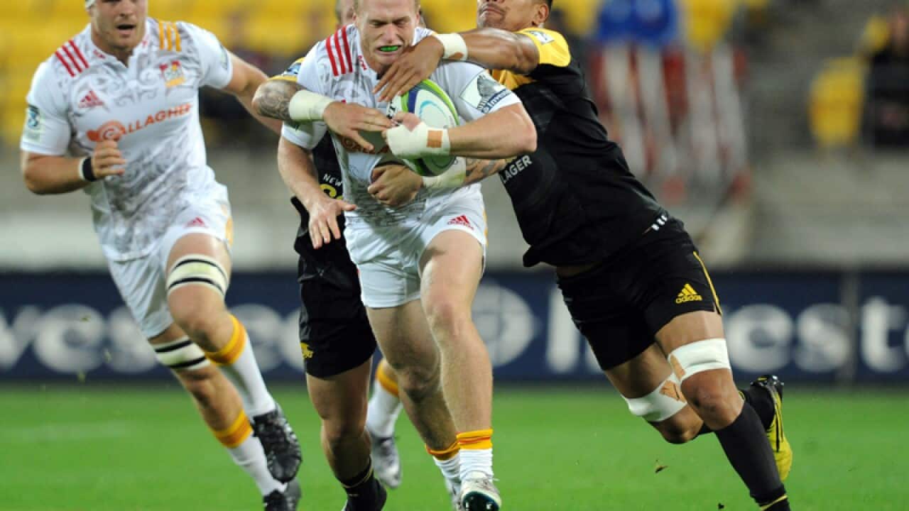 Sam Nicol of the Chiefs (L) caught by Ardies Savea of the Hurricanes