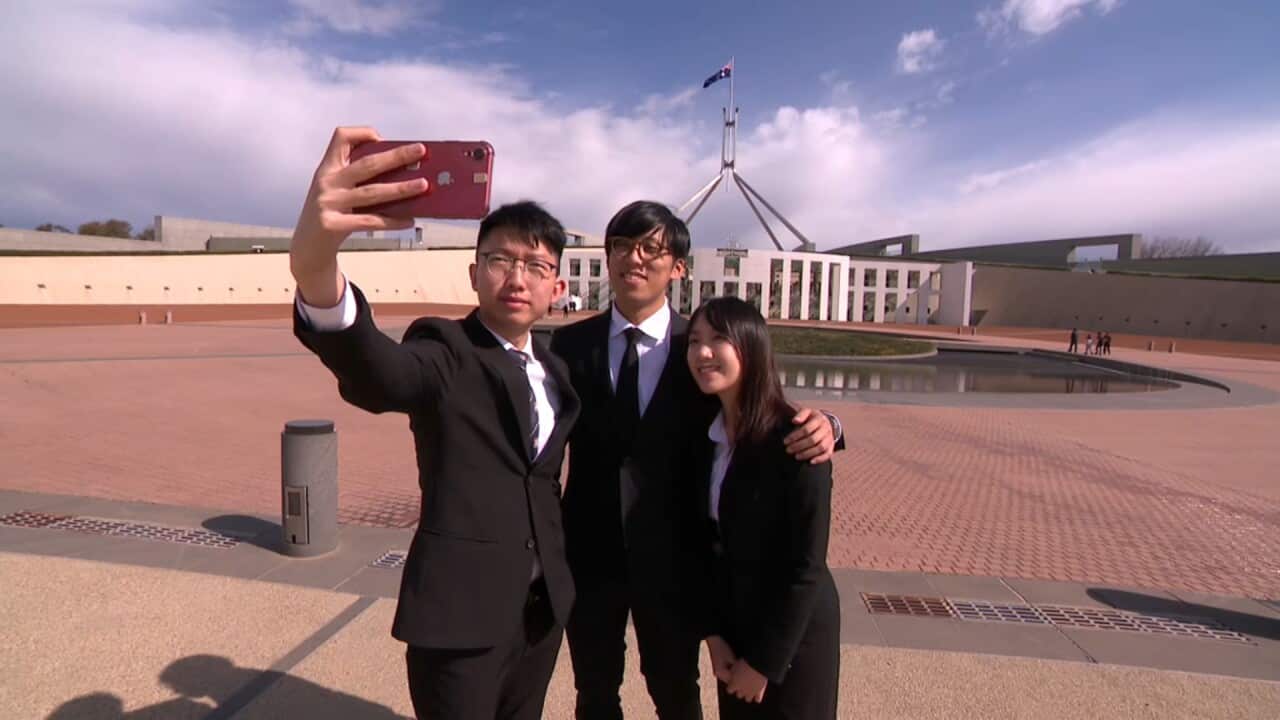 The student protesters take a photo outside Parliament House.