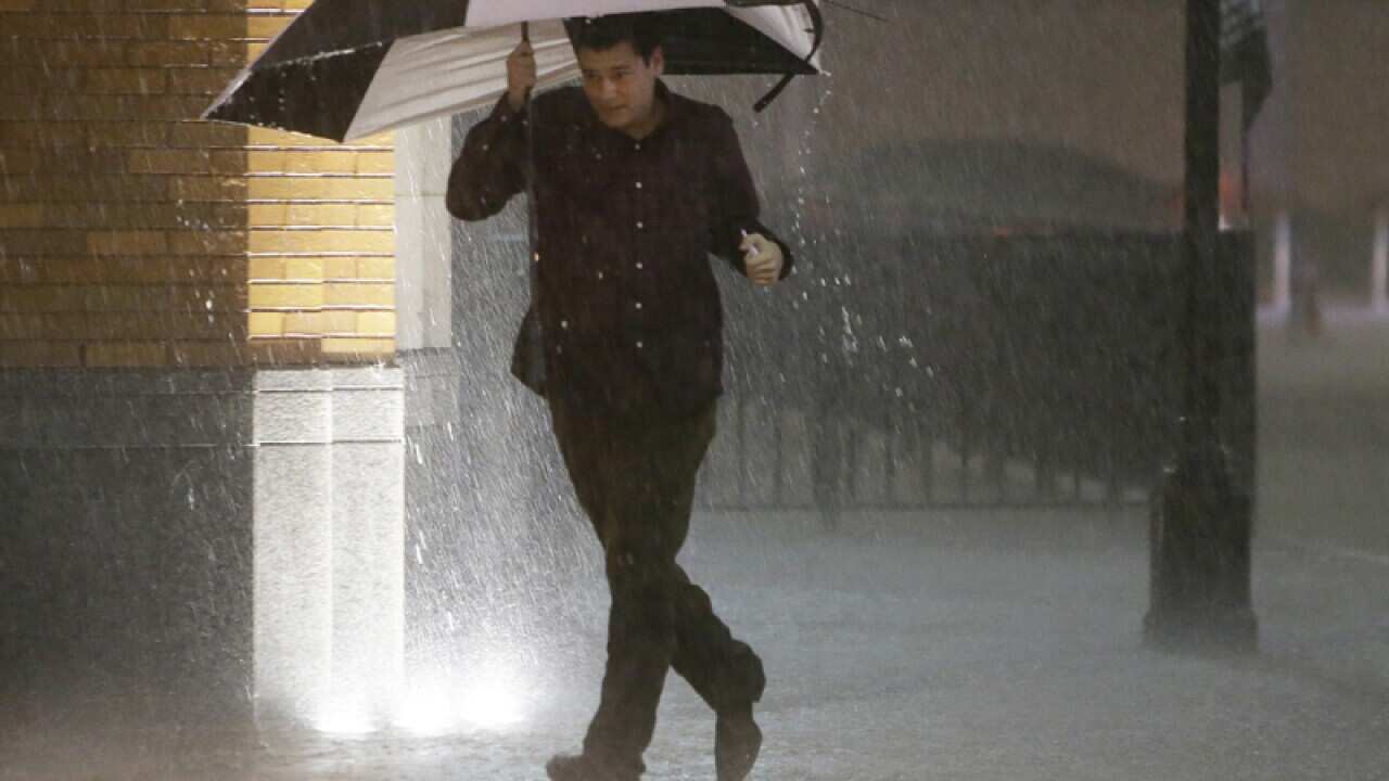 A man runs as sirens sound during a severe storm over downtown Dallas.