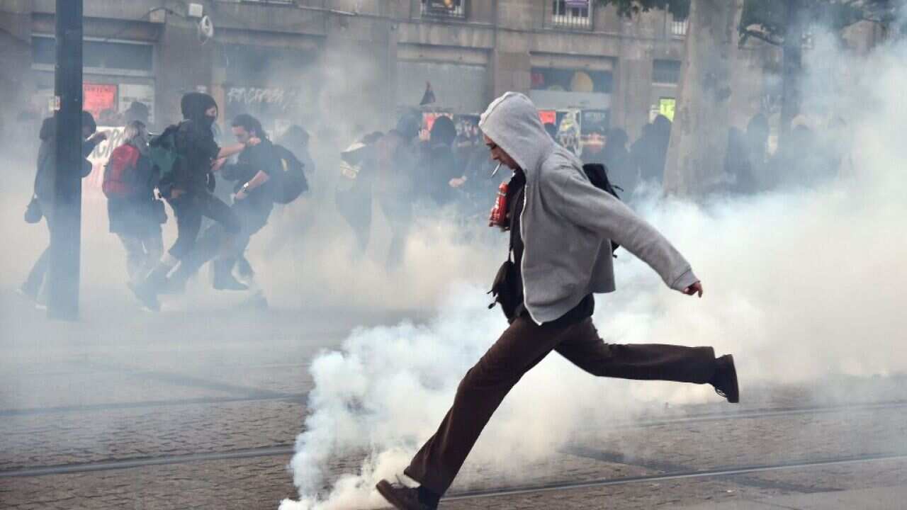 A protestor throws back tear gas in the streets of Nantes in eastern France, following election announcement, May 7, 2017.
