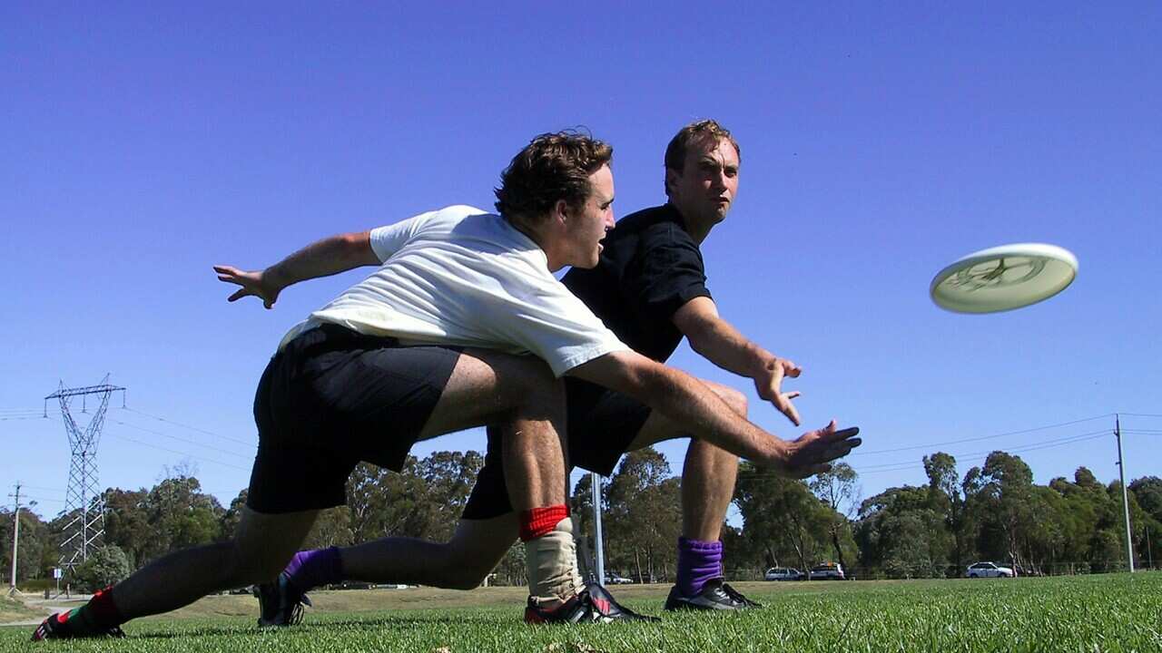Jonathon Potts (right) throws a Frisbee as David O'Brien tries to block at National Training Camp at the AIS in January 2004. (Australian Flying Disc Association/AAP)