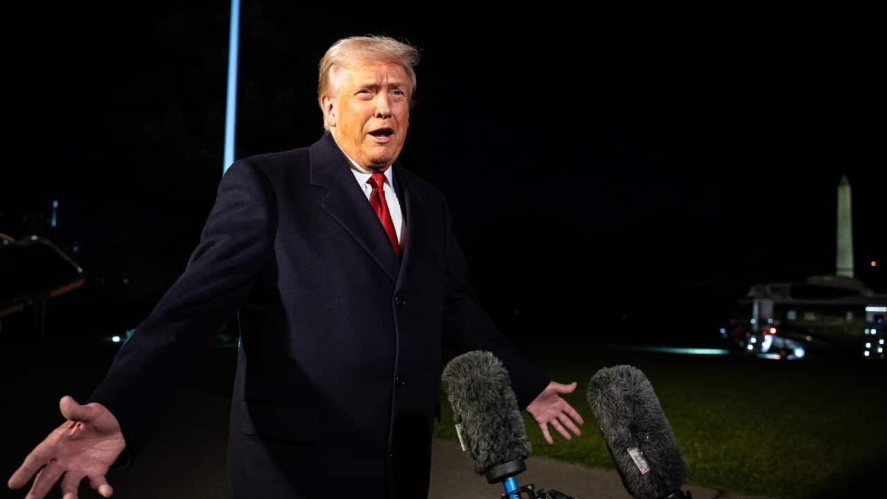 Donald Trump speaking to reporters outside the White House at night.