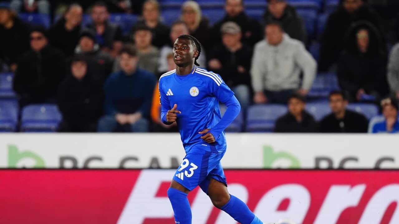 A sportsman in a blue uniform is running on the field.