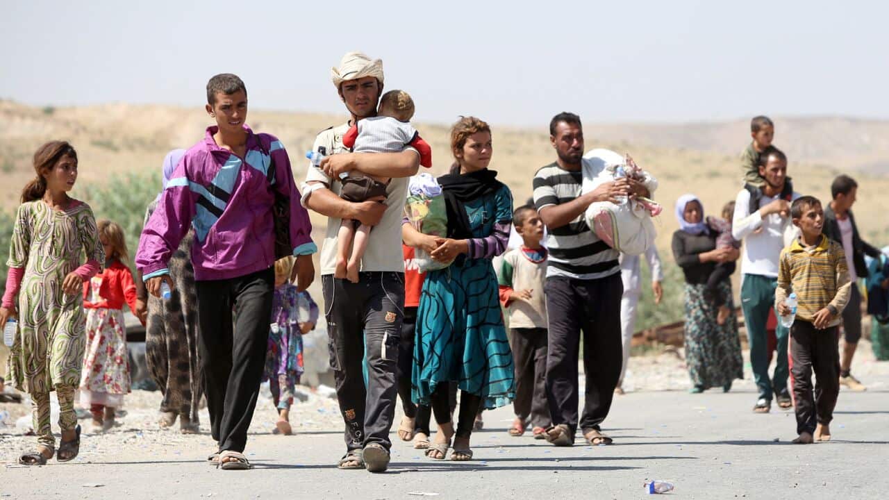 A displaced Iraqi man from the Yazidi community carries his daughter as they cross the Iraqi-Syrian border at the Fishkhabur crossing, in northern Iraq. (AFP PHOTO/AHMAD AL-RUBAYE)