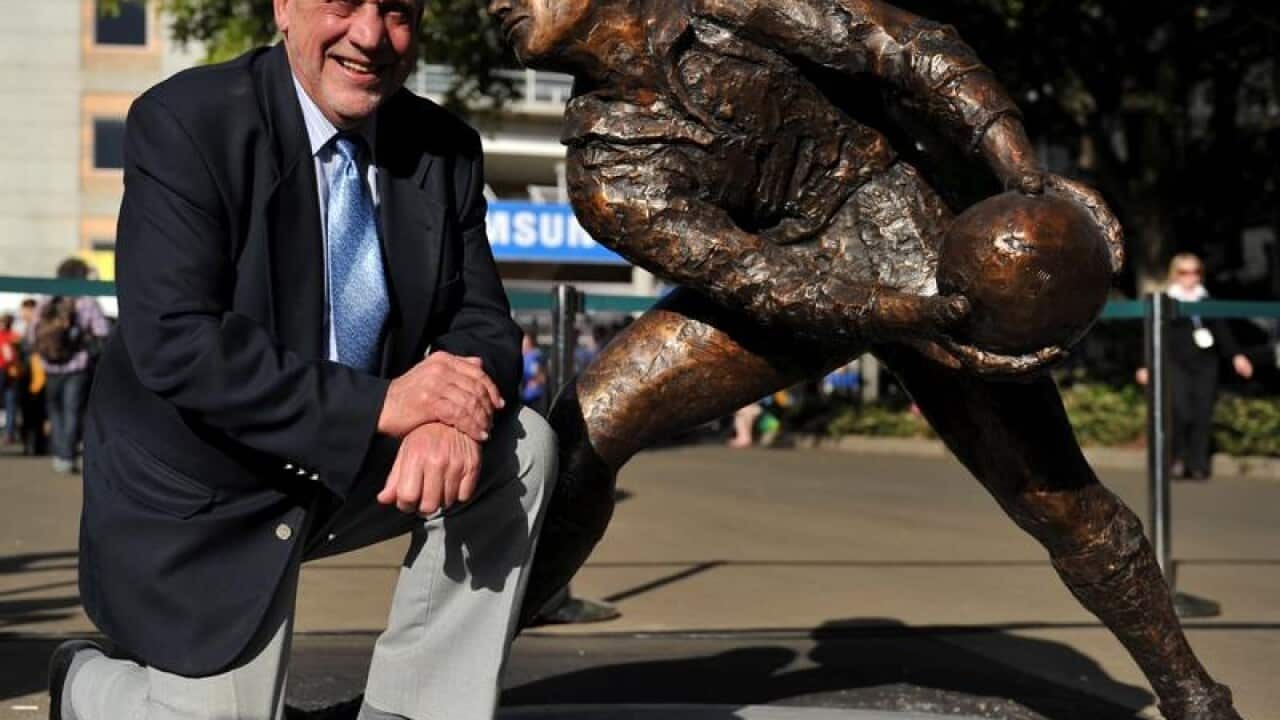 Ken Catchpole, poses with a sculpture of himself