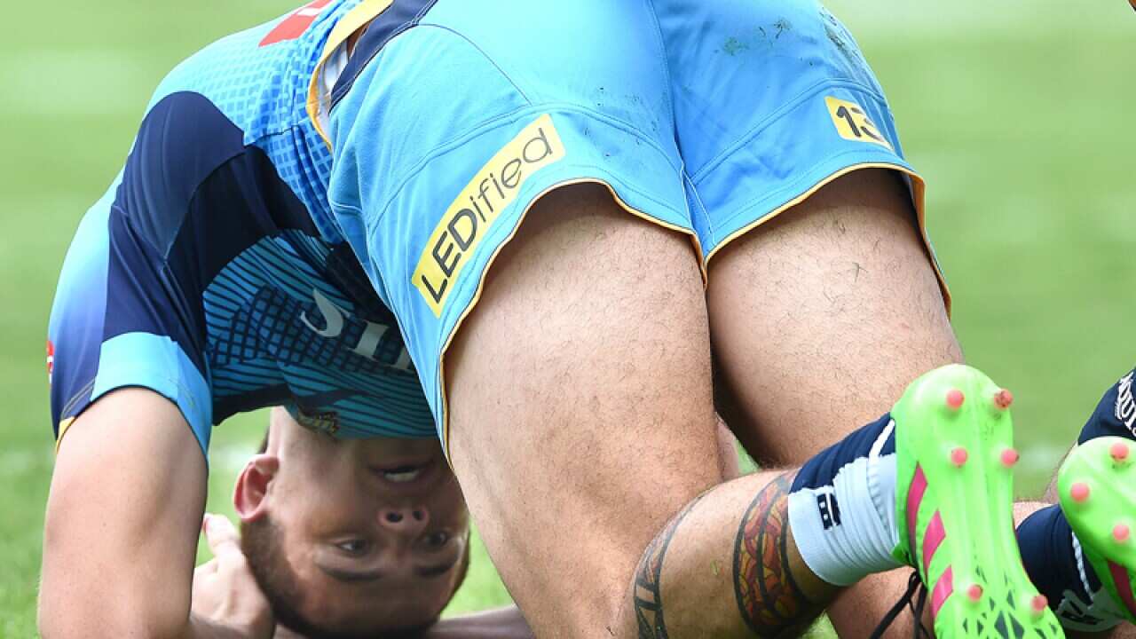 Titans player Nathan Davis is assisted after sustaining an injury