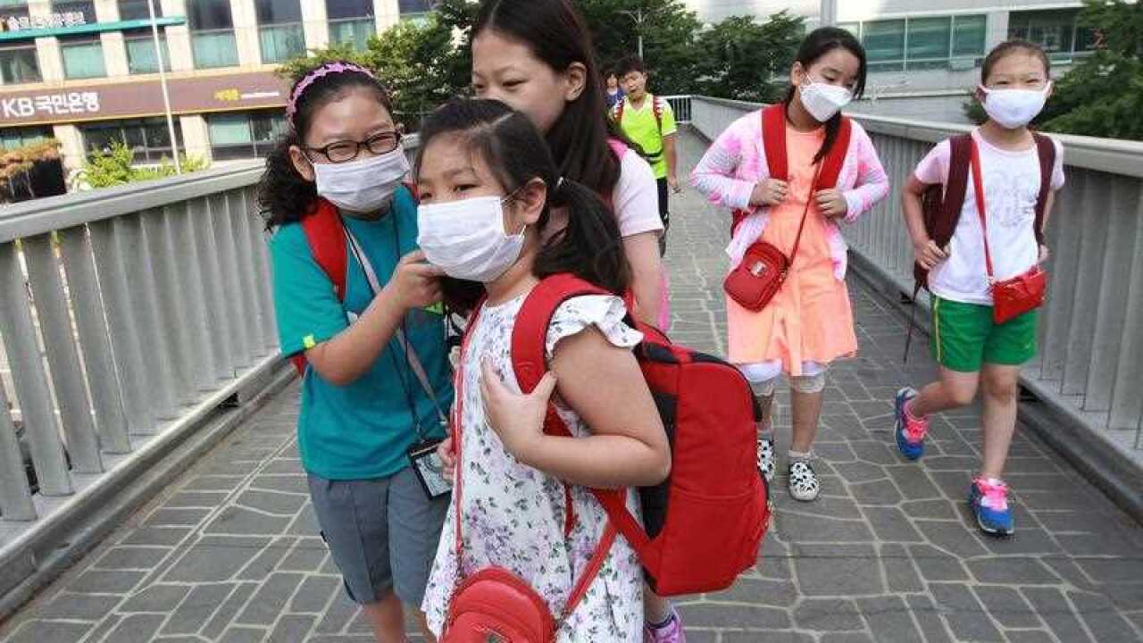 South Korean elementary school students wear masks as a precaution against the MERS, Middle East Respiratory Syndrome, virus as they go to school in Seoul, South Korea, Wednesday, June 10, 2015. (AAP)