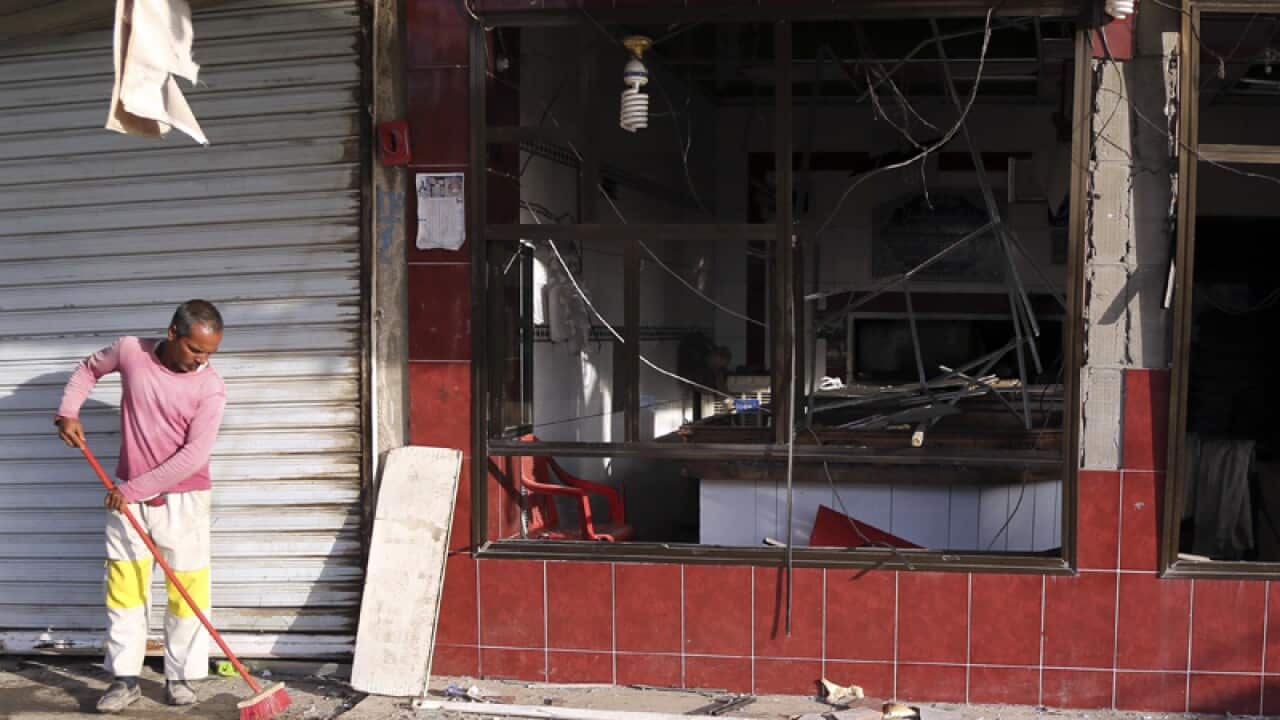 A man cleans the site of a car bomb in Baghdad