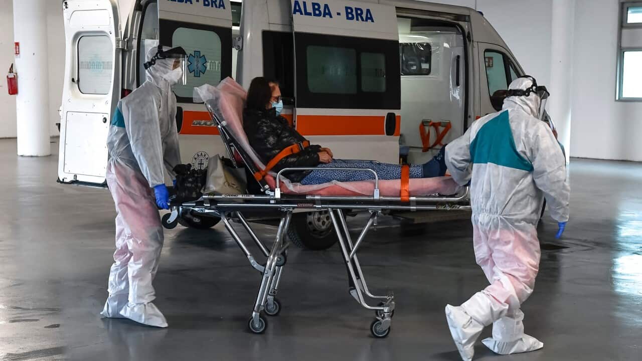 VERDUNO, ITALY - March 31, 2020: Personal healthcare workers with Personal Protective Equipment (PPE) transport infected Coronavirus (COVID 19) patients at the Verduno Hospital.
