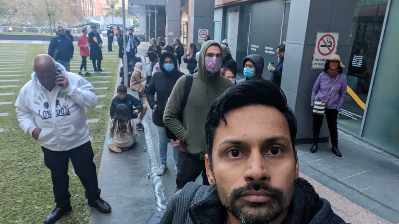 A man takes a selfie outside the Sydney passport office.