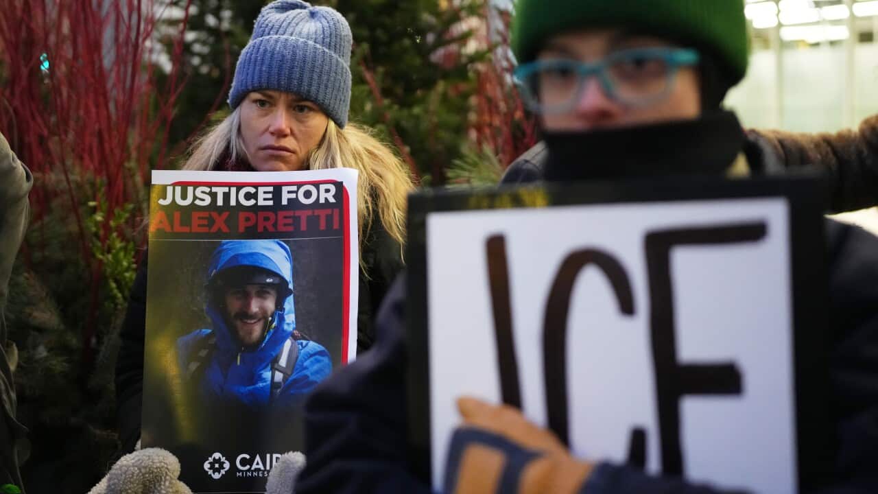 Demonstrator holds signs during a protest outside the office of Sen. Amy Klobuchar, D-Minn., on Monday, Jan. 26, 2026, in Minneapolis, after Alex Pretti was fatally shot by a U.S. Border Patrol officer over the weekend