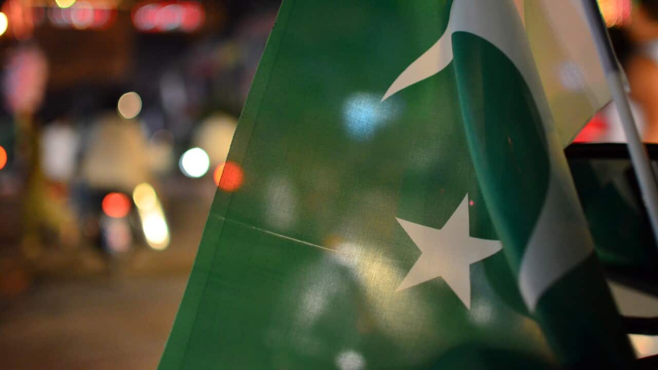Pakistan day independence or national day celebrations on the city streets, where crowd is motivated to join the parade and cheering with Pakistan flags.