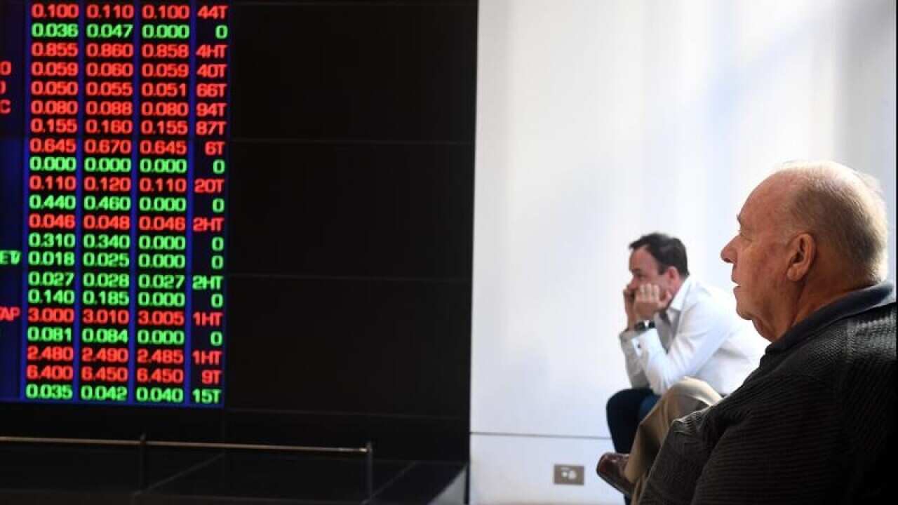 two men sitting watch ASX information board