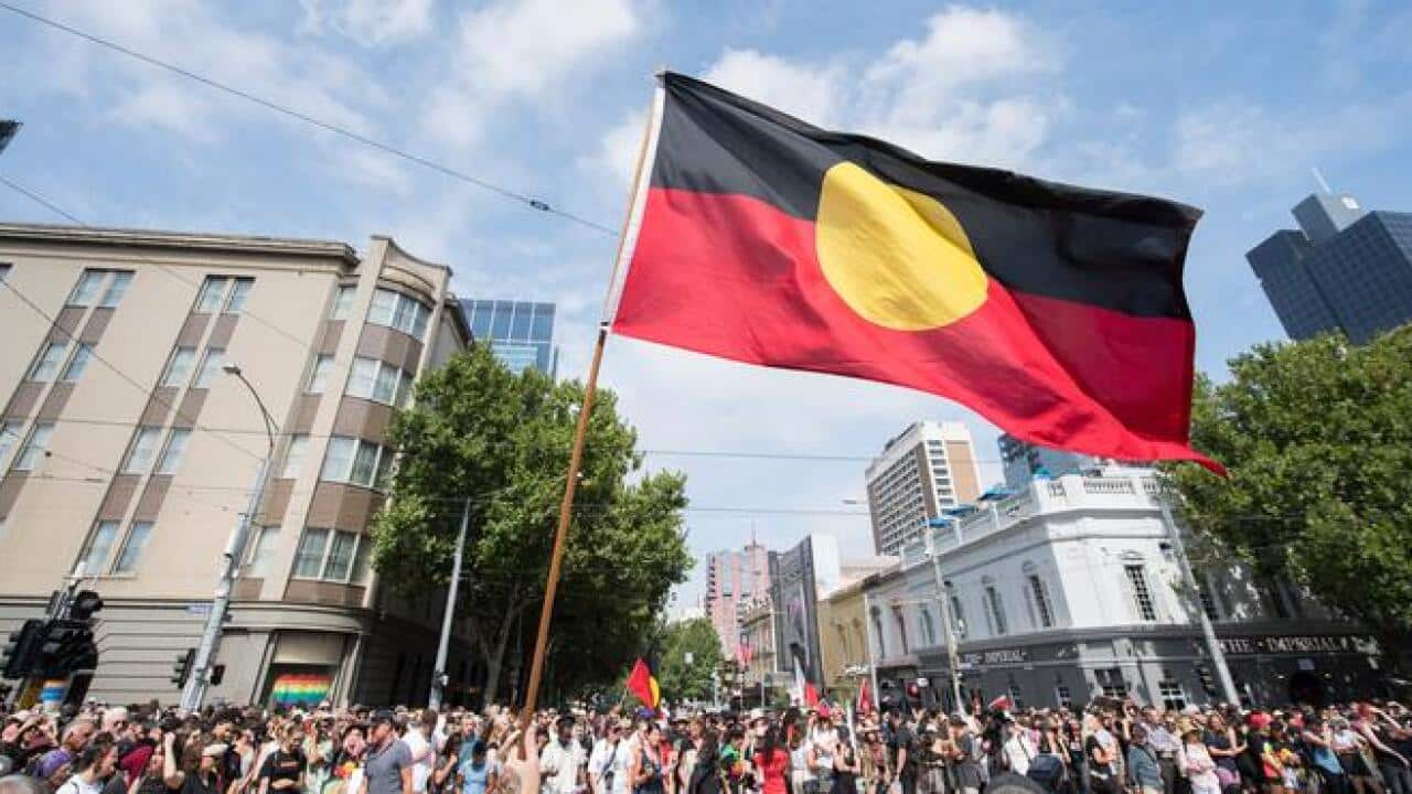Protesters holding Aboriginal falg