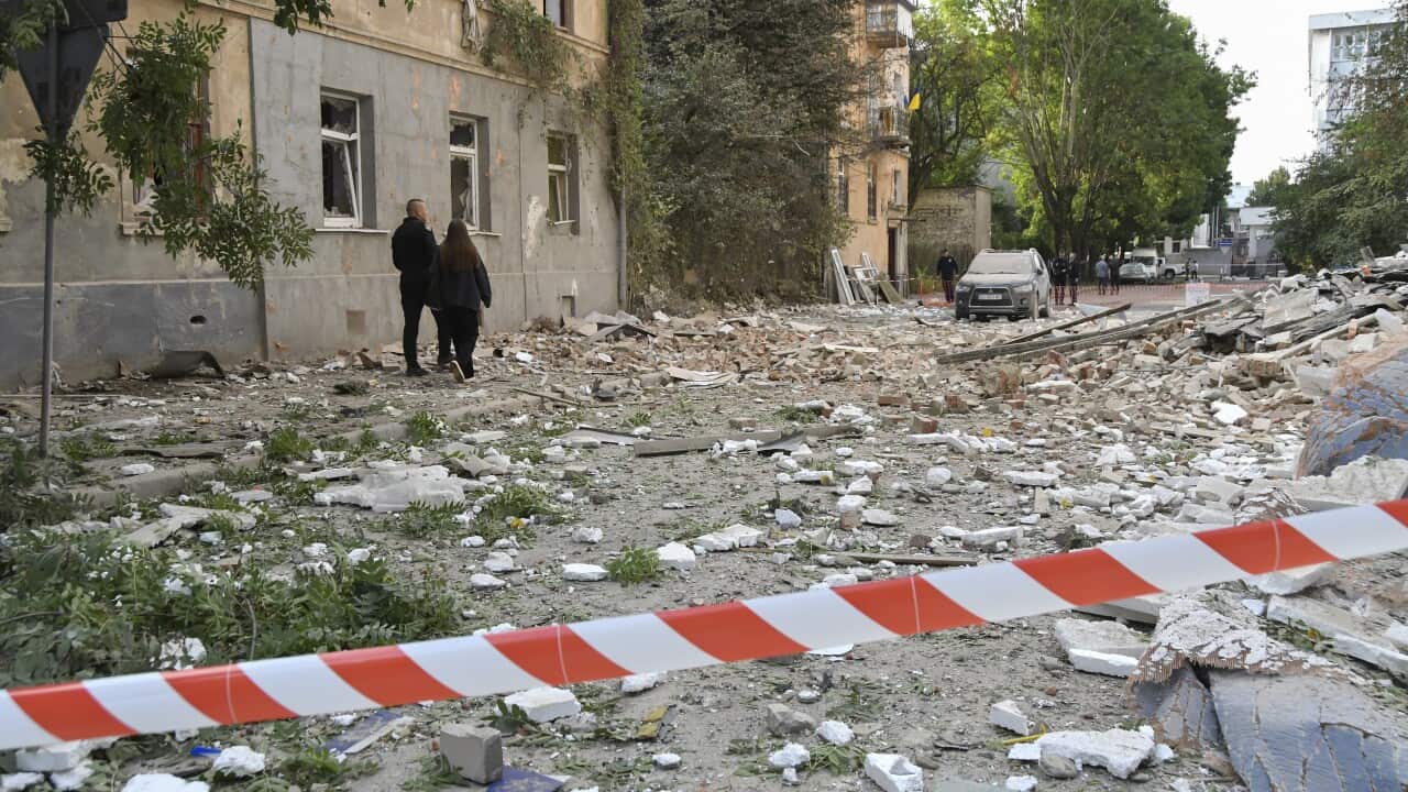 People standing amid rubble in a city street.