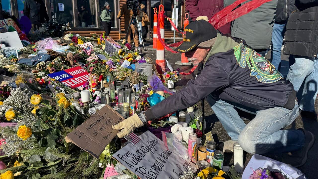 A man places a sign that says "In remembrance of my angel" at a memorial set up at the location where Veterans Affairs nurse Alex Pretti was shot by U.S. federal agents, in Minneapolis,