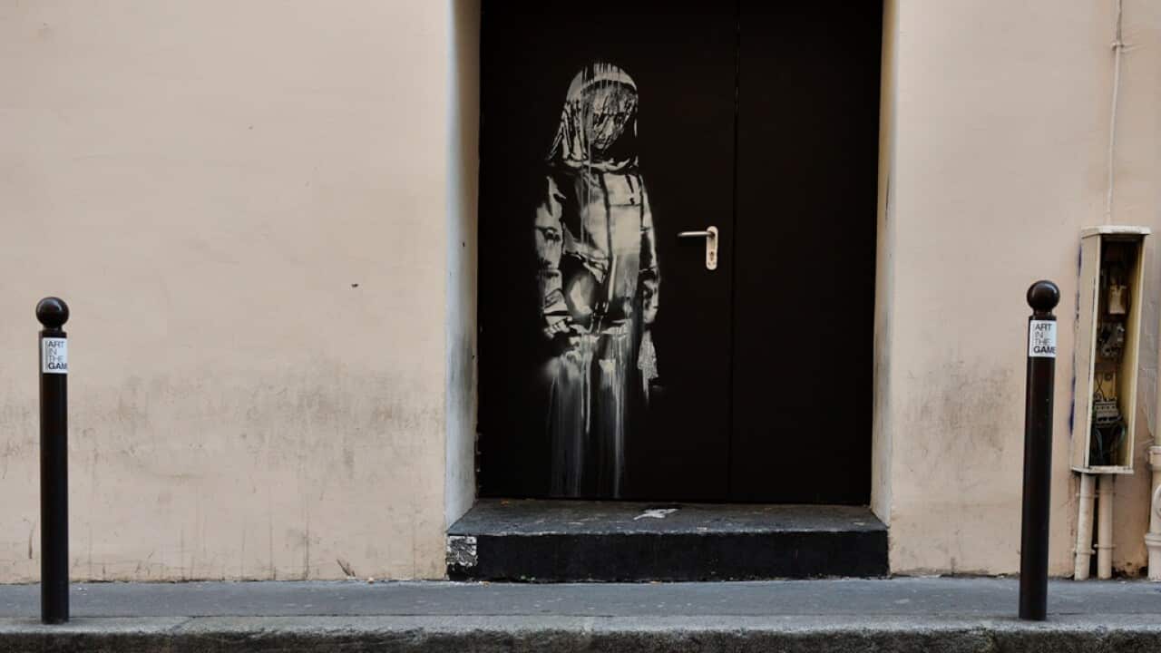 An artwork believed to be attributed to Banksy is of a woman veiled in mourning next to the Bataclan concert venue in Paris
