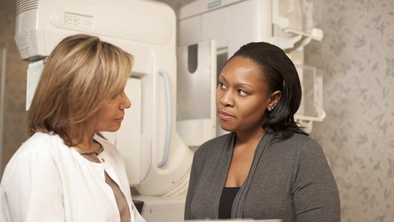 Nurse with patient going over mammogram procedure