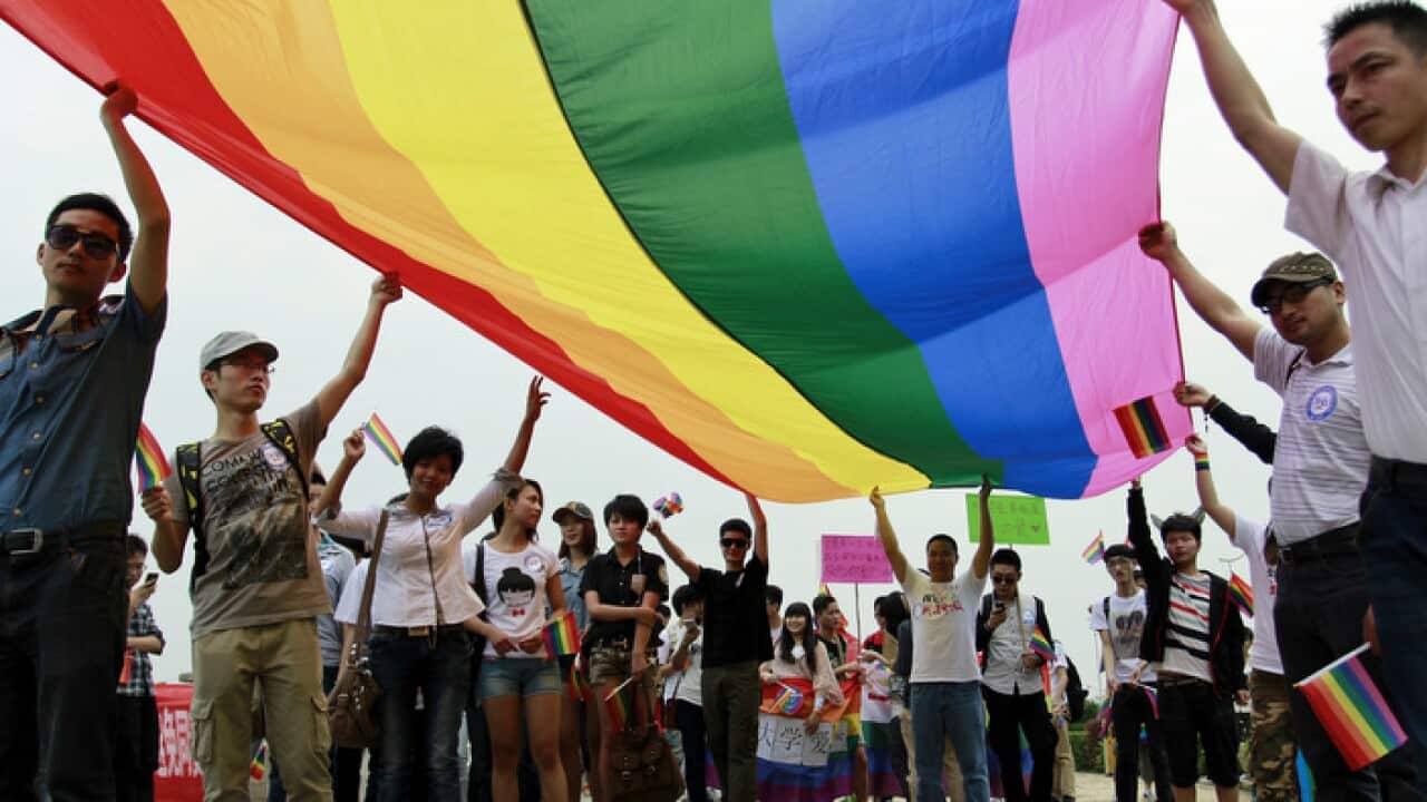 Chinese activists hold a rainbow banner as they take part in a gay pride parade in Changsha in south China's Hunan province, Friday, May 17, 2013. Hundreds of sexual minorities and their supporters marched through a street . (AP Photo) CHINA OUT