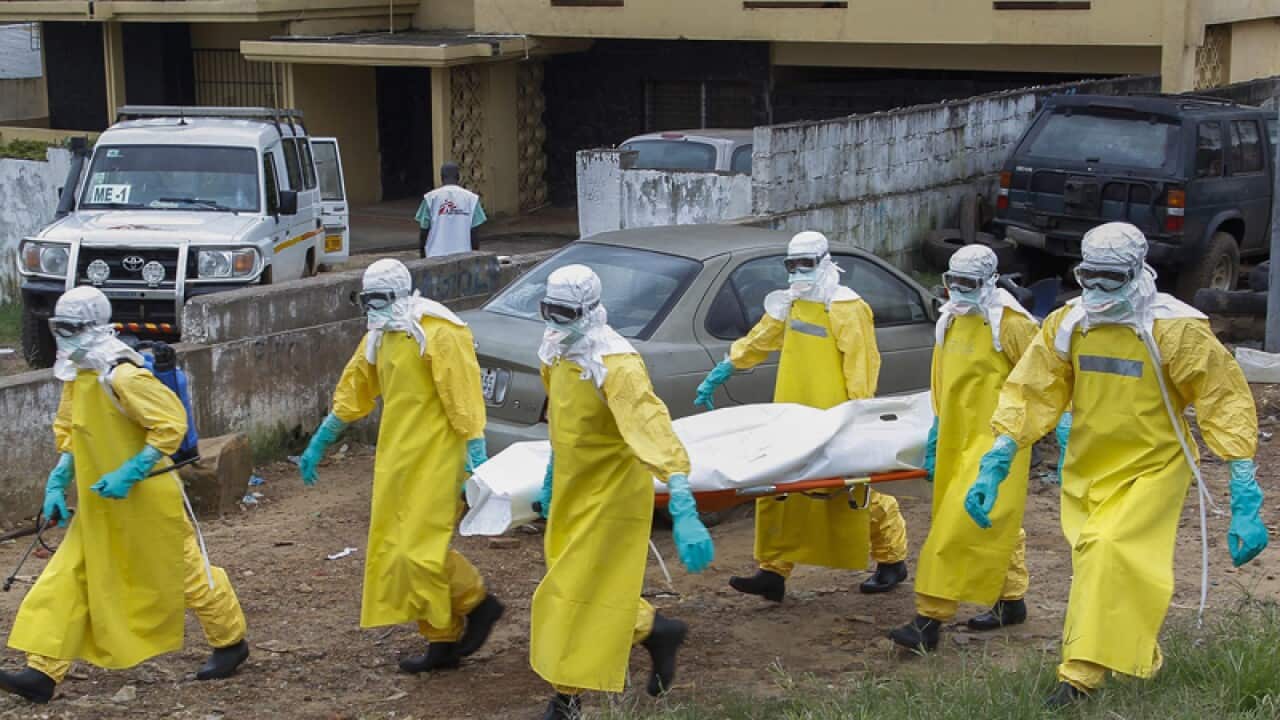 Healthcare workers in Liberia on their way to bury and Ebola victim.