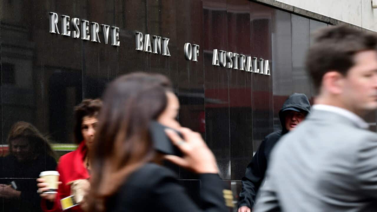 People walk past a building with a sign that reads: "Reserve Bank of Australia".