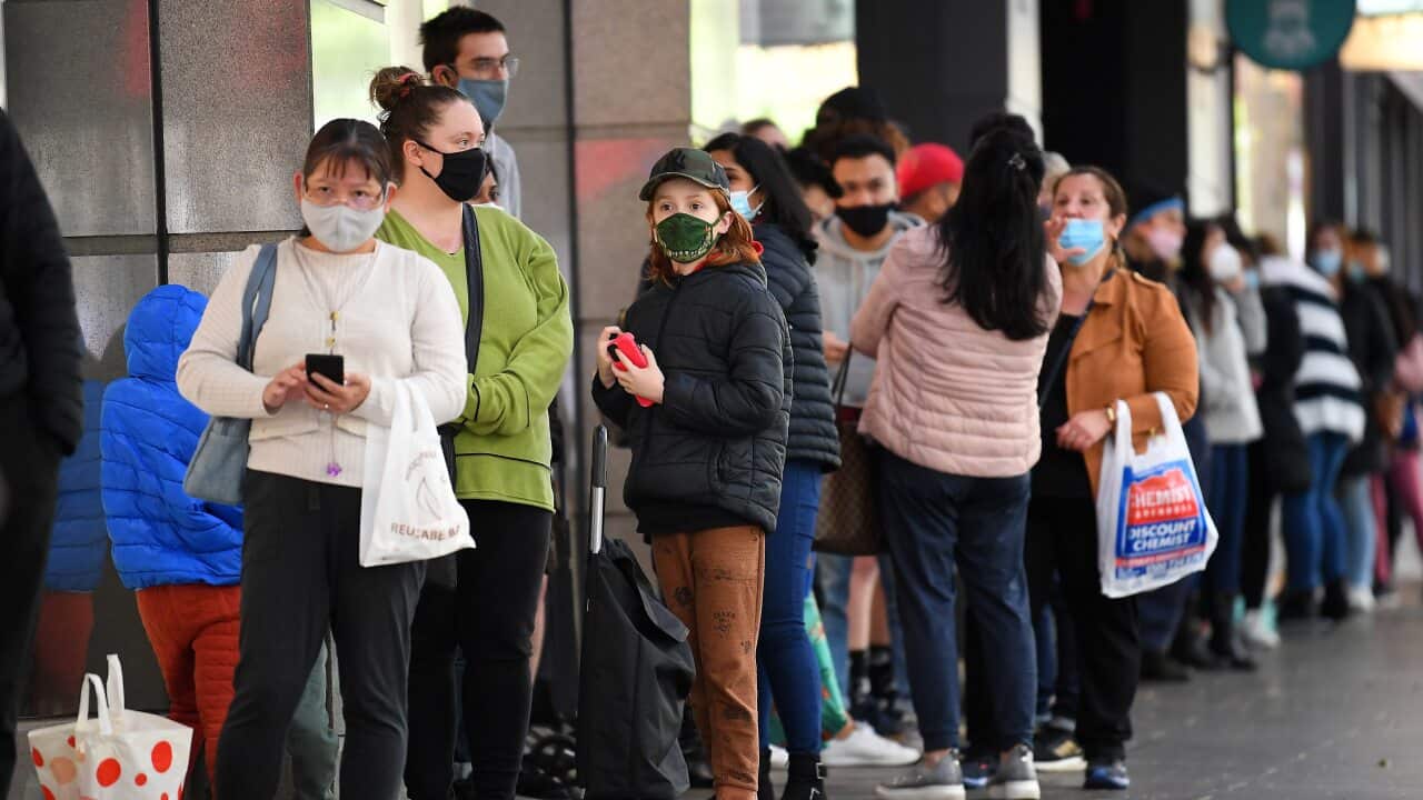 People are seen lining up outside of a retail store in Melbourne, Friday, October 29, 2021