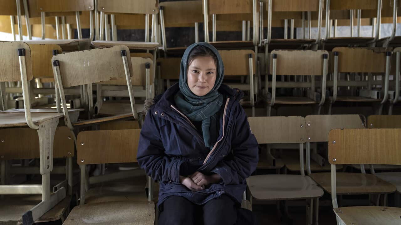 Halimah, 13-year-old schoolgirl, poses for a photo in an empty classroom in Kabul