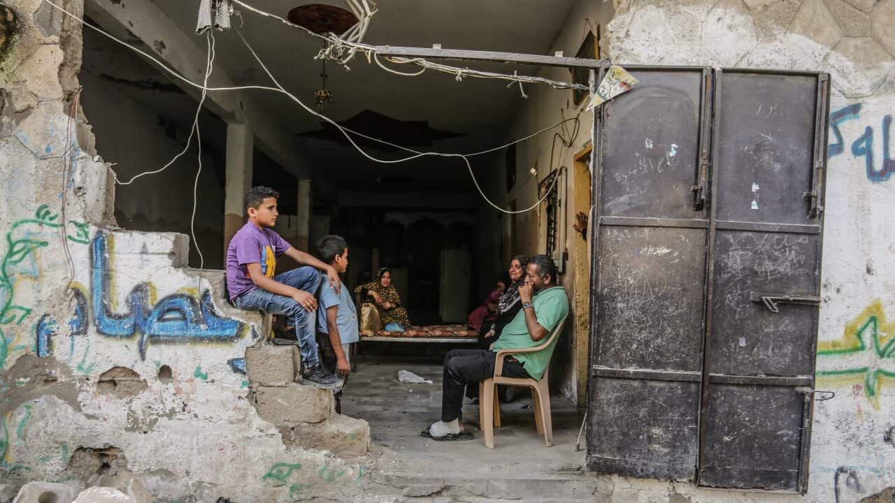 Palestinians sit among the rubble of their destroyed homes after a ceasefire in Gaza comes into effect.