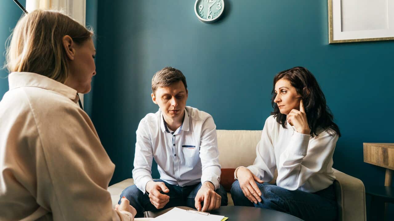 Three persons talking in the office