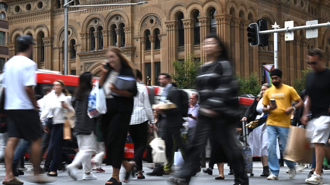 People walking in a street wearing corporate attire.
