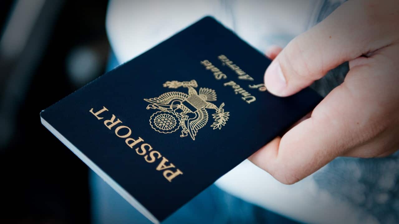 A photo of a person holding a United States passport, taken in Dallas. 