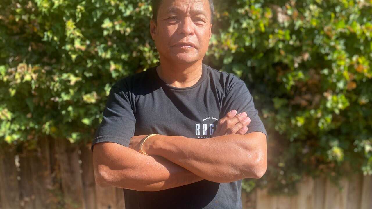 A man stands with his arms folded