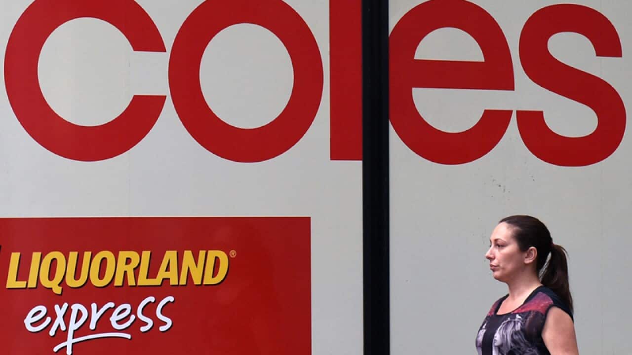 A pedestrian walks past Coles store in Sydney