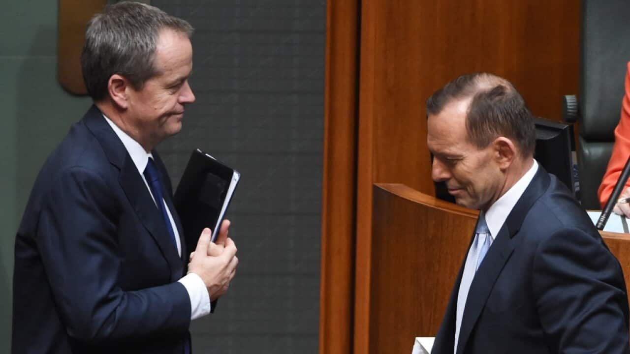 Leader of the Opposition Bill Shorten and Prime Minister Tony Abbott crossover during a division during Question Time at Parliament House in Canberra, Wednesday, June 24, 2015.  (AAP Image/Mick Tsikas) NO ARCHIVING