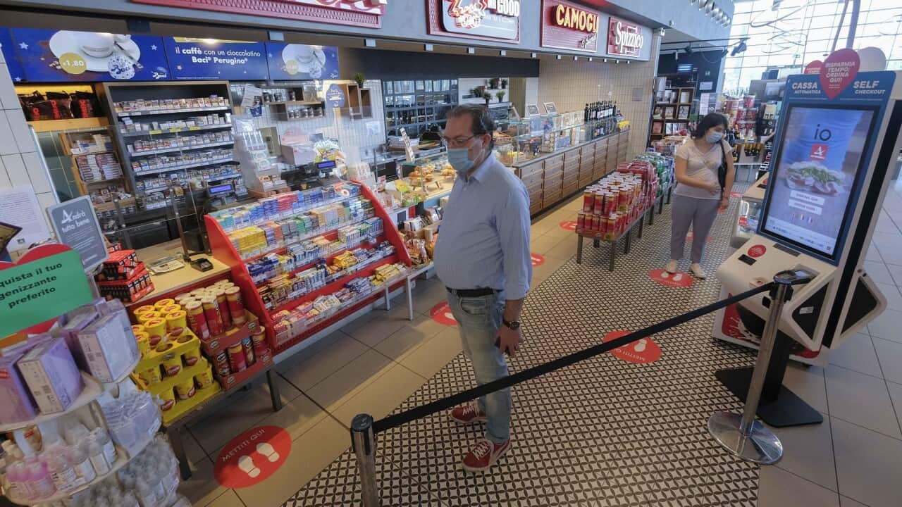 Clients wait in a line at a motorway grill after virus restrictions were eased in Milan, Italy