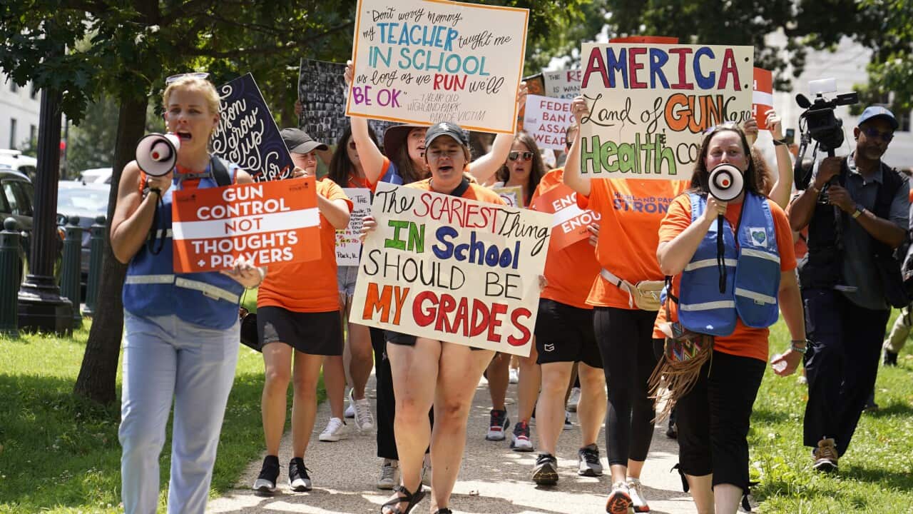 Group of protesters march with signs calling for gun control.