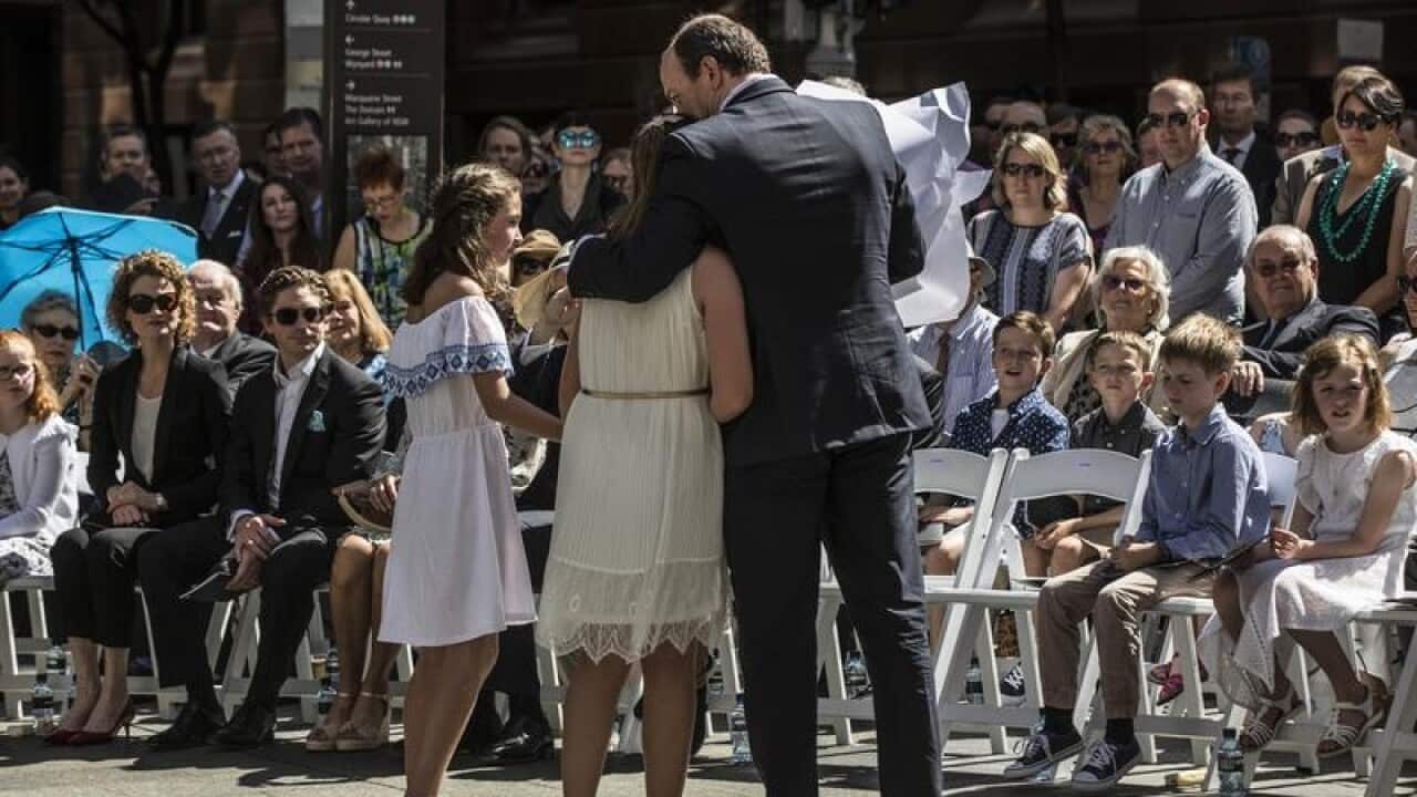 It was an emotional day for Katrina Dawsons's daughter Chloe (hugging her father) as a  permanent tribute to victims of the Lindt Cafe siege is unveiled.