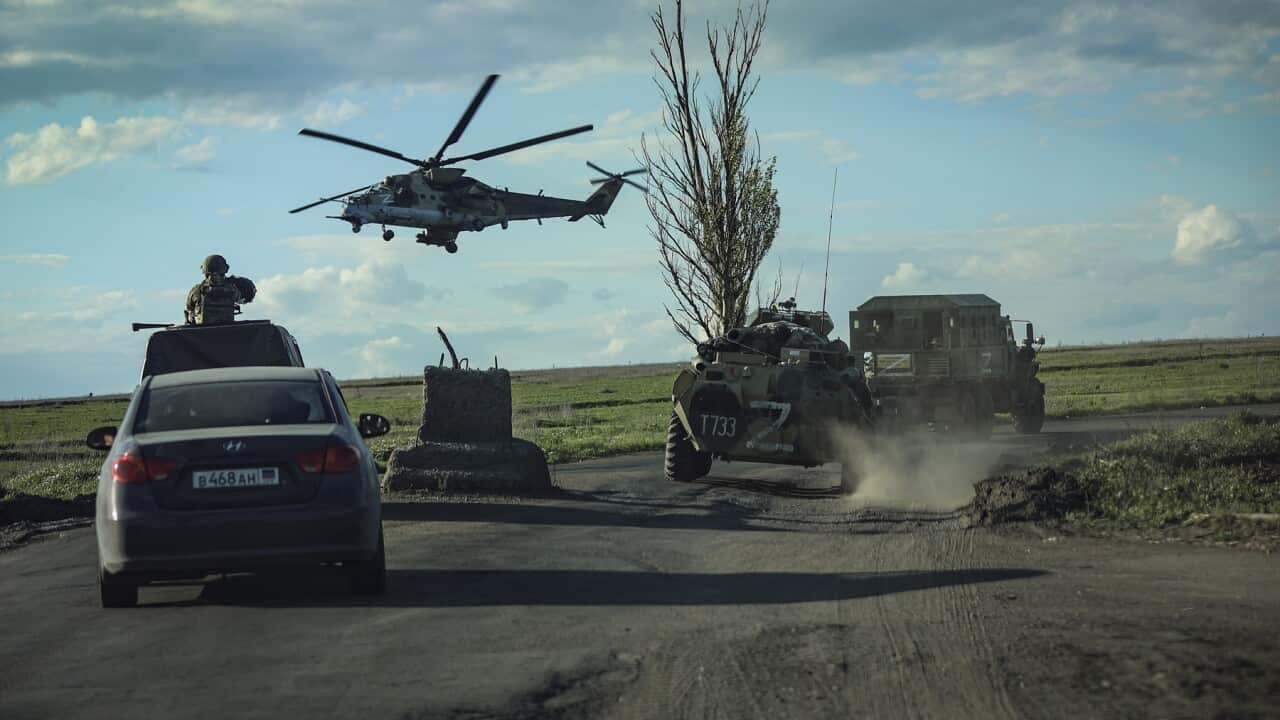 Russian military vehicles follow buses carrying Ukrainian servicemen being evacuated from the Azovstal steel plant
