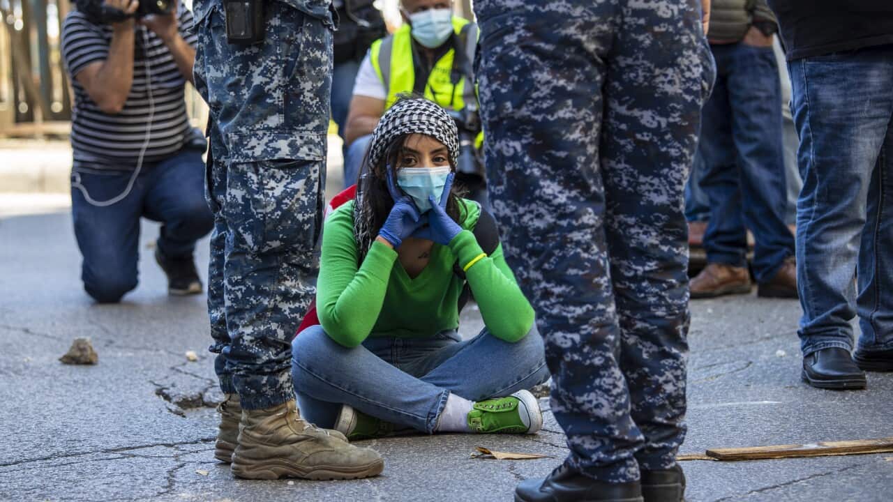 An anti-government protester blocks a road during May Day protest near the Lebanese Central Bank in Beirut.