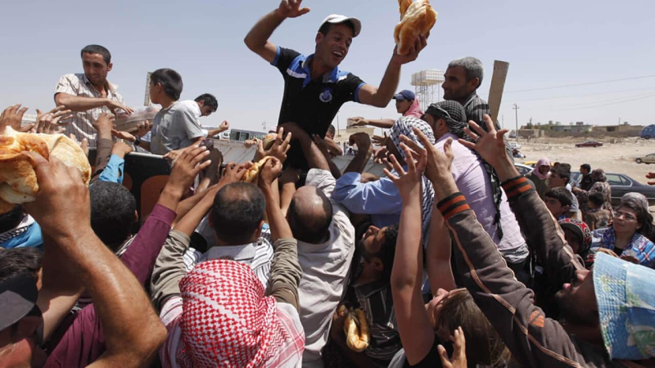 Syrian refugees gather for food aid