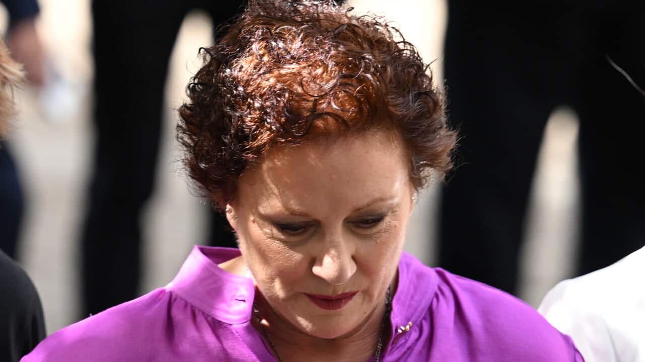 A woman in a purple top looking down.