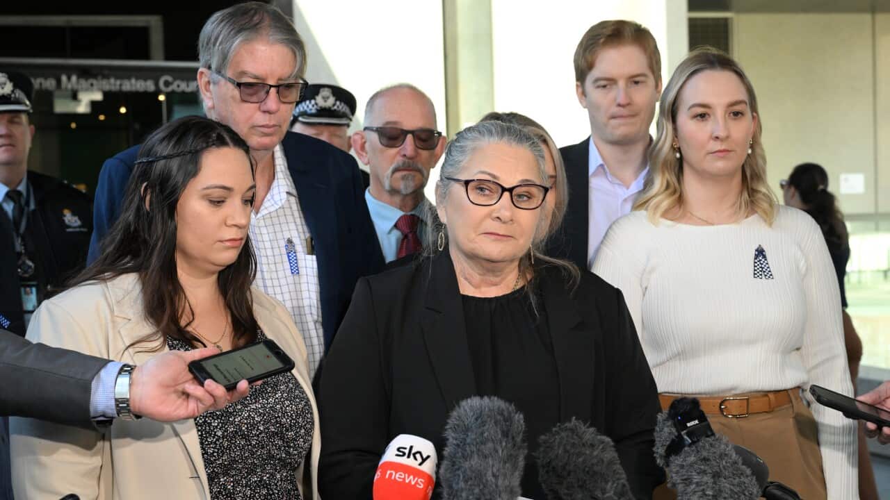 A gourp of men and women speaks to the media outside a court
