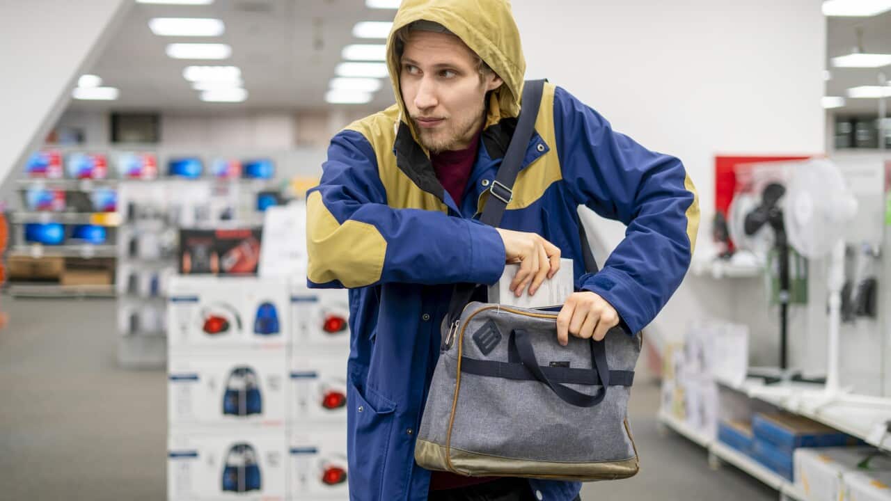 shoplifter in the electronic store supermarket stealing new gadget f