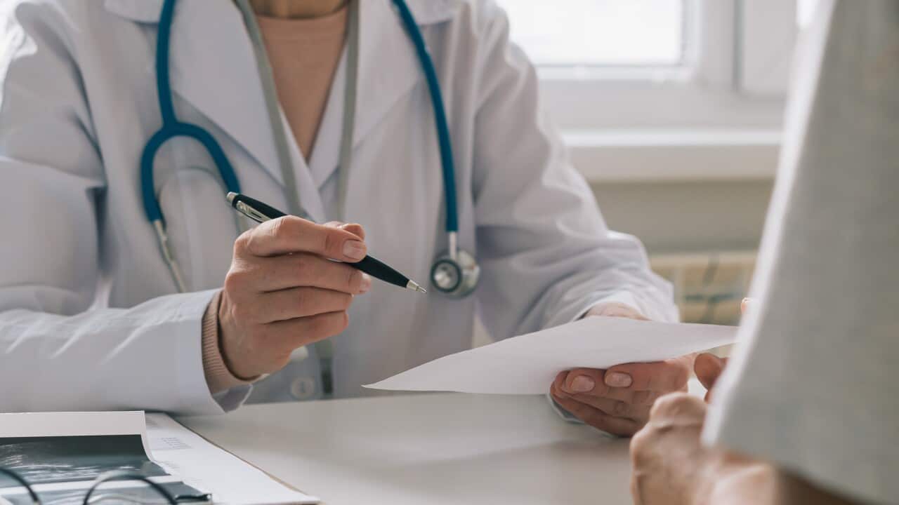Unrecognizable doctor consulting patient. Giving piece of paper with instructions and recommendations